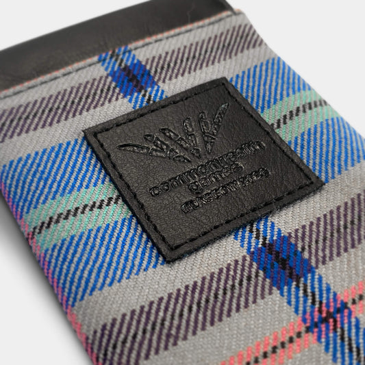 Close up view of Glasgow 2026 Tartan Glasses Sleeve on grey background showing debossed logo detail