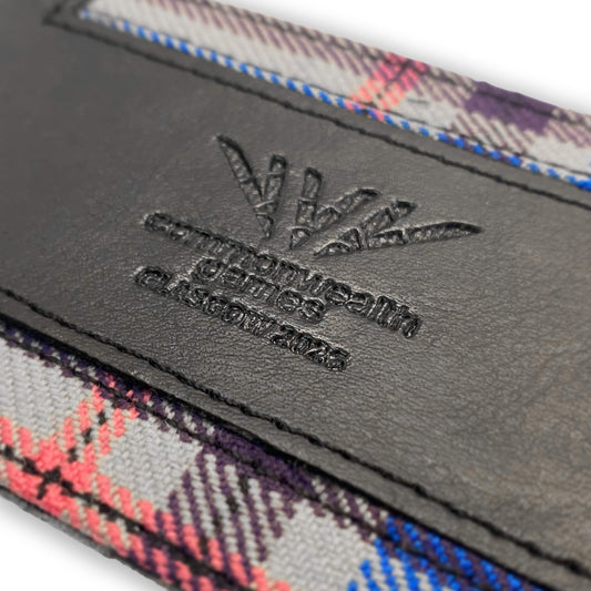 Close up view of Glasgow 2026 Tartan Luggage Tag on grey background showing debossed logo detail