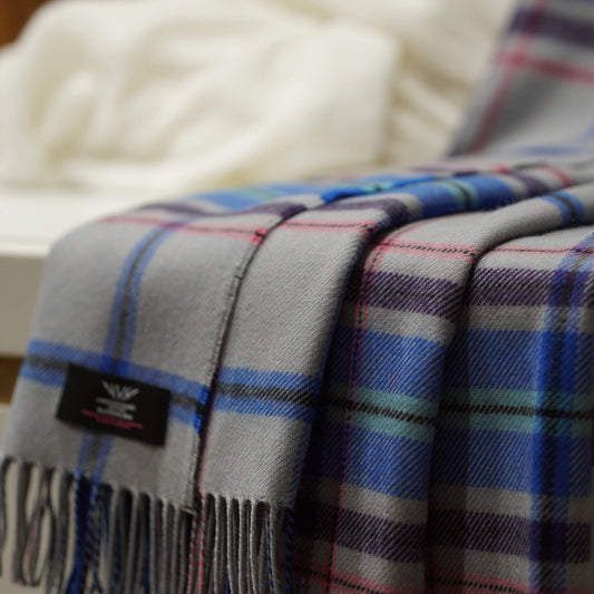 100% lambswool throw with Official Glasgow 2026 tartan design with closeup of label