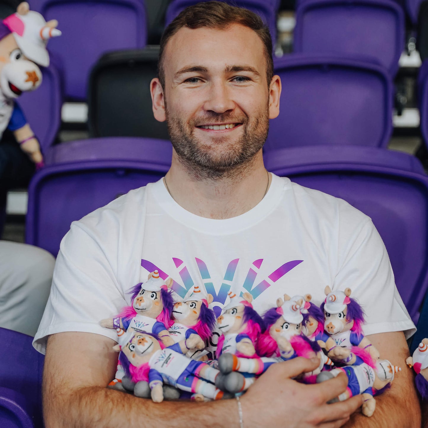 Man holding a bunch of Glasgow 2026 Finnie Mascots - 15cm