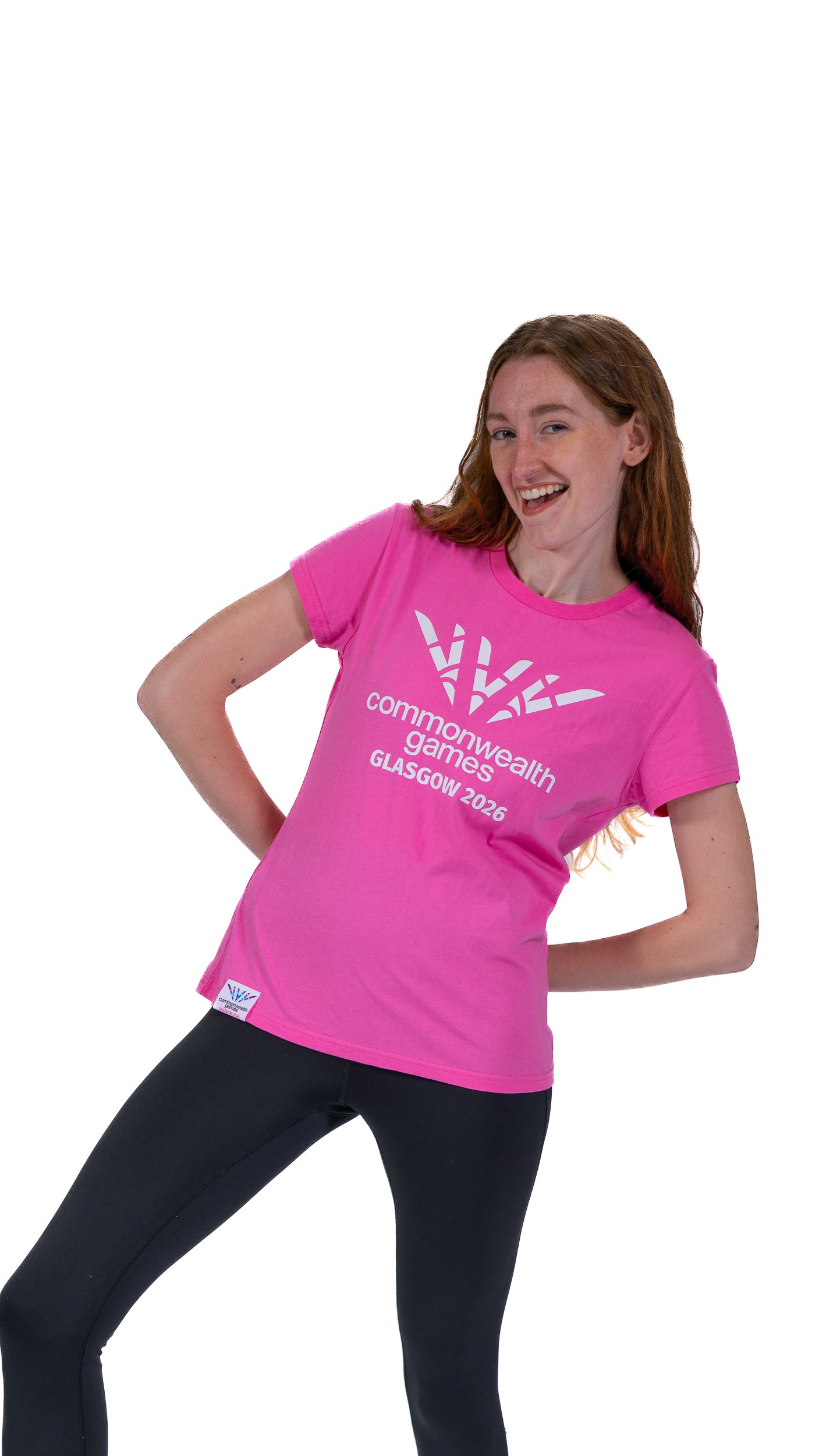 Woman wearing pink fitted t-shirt with single colour, white Glasgow 2026 logo.