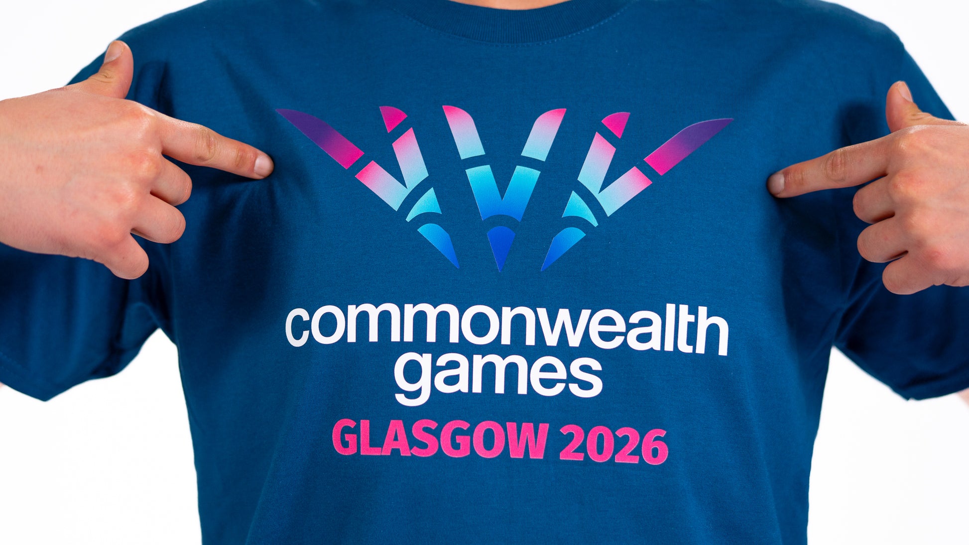 Close up of man wearing denim blue t-shirt showing full colour Glasgow 2026 Logo.
