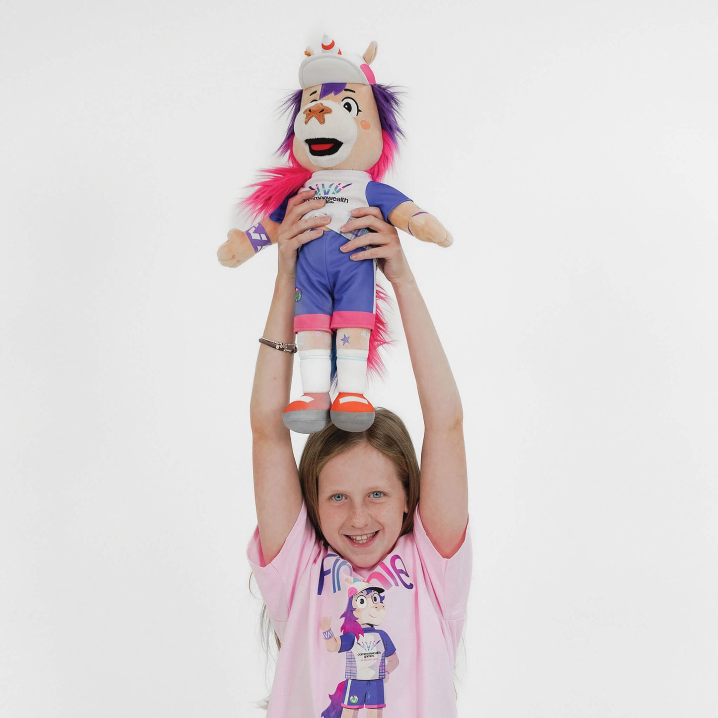 Young girl holding a 50cm Finnie Glasgow 2026 Mascot Plush above her head