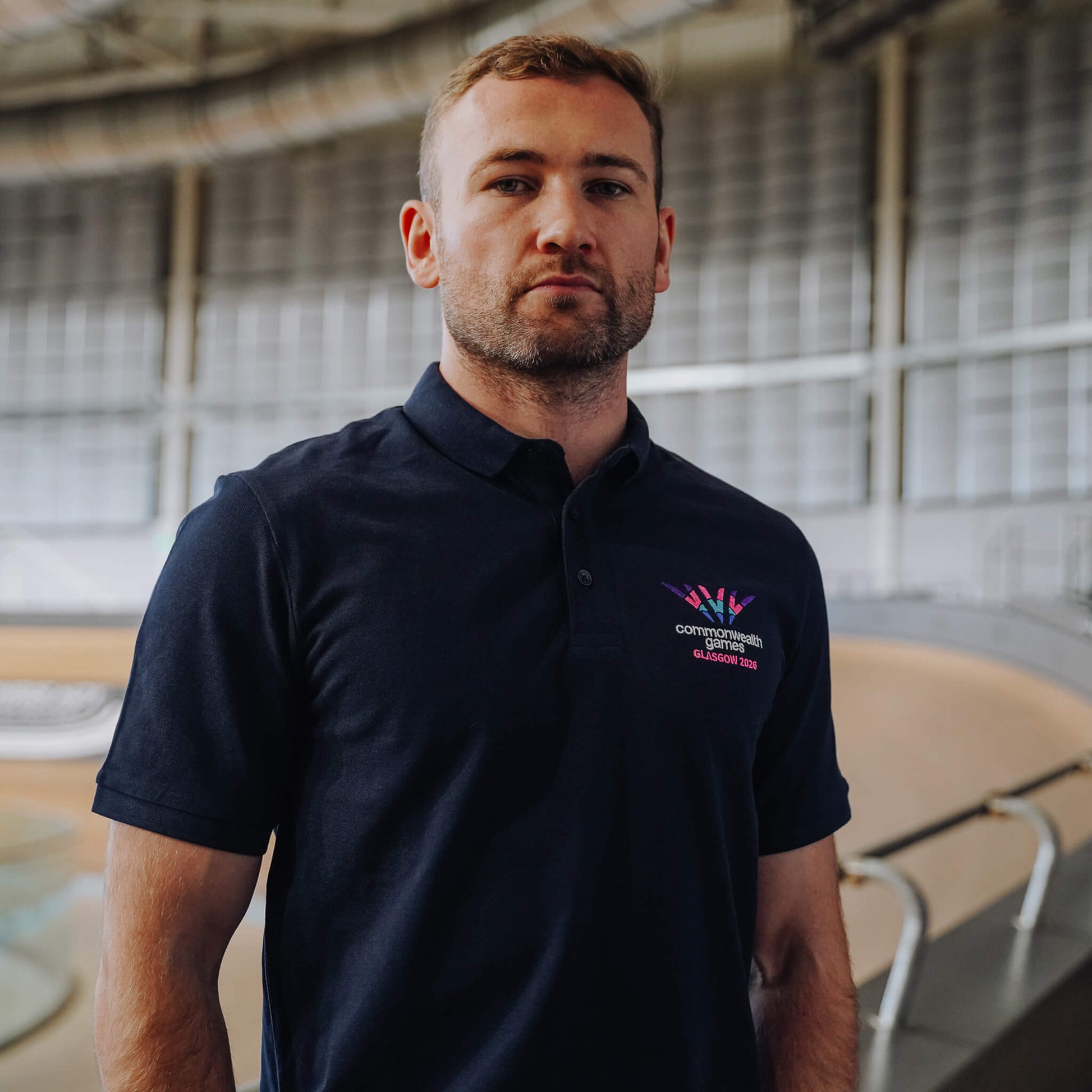 Man wearing Glasgow 2026 logo polo shirt.