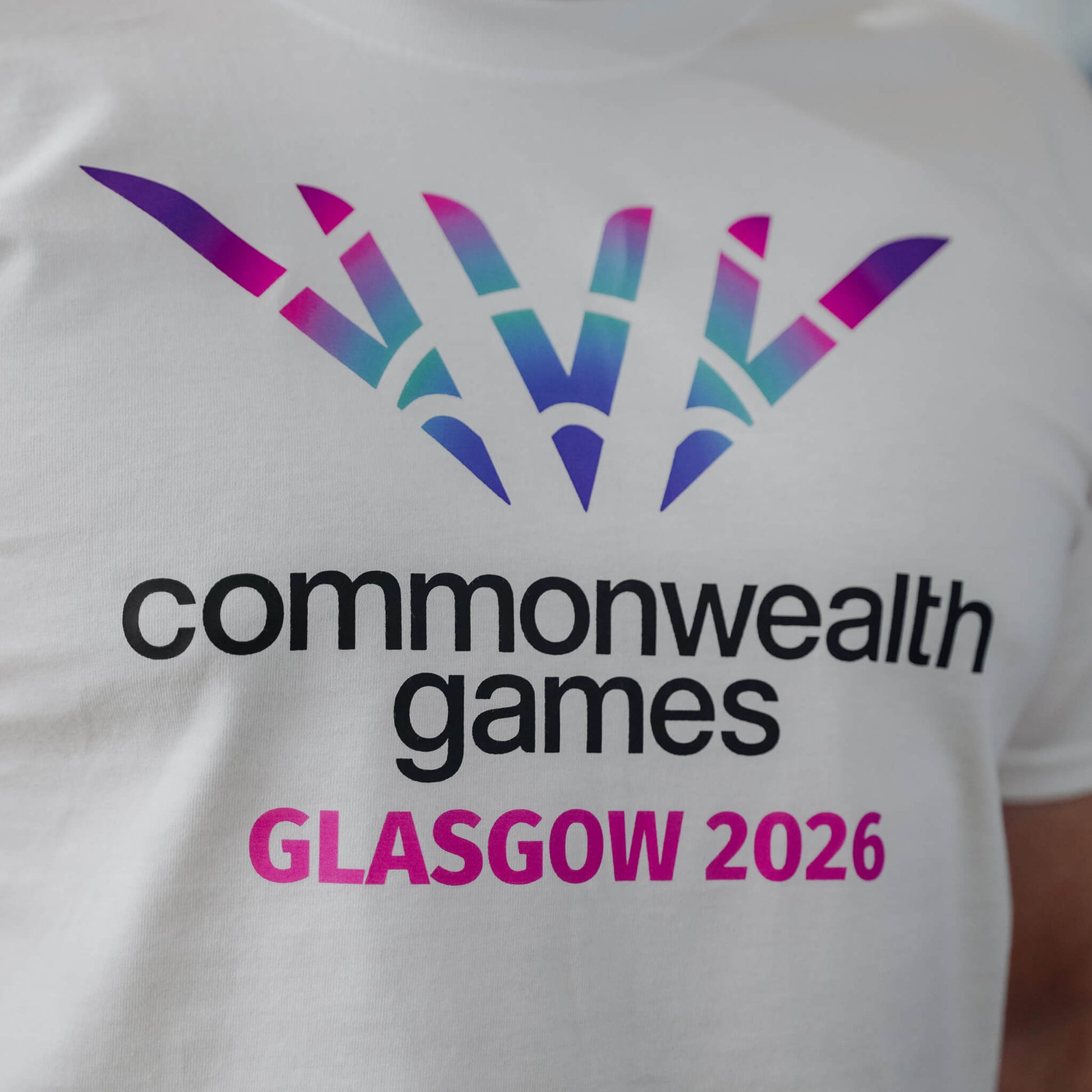 Close up of white Glasgow 2026 logo t-shirt showing chest print.