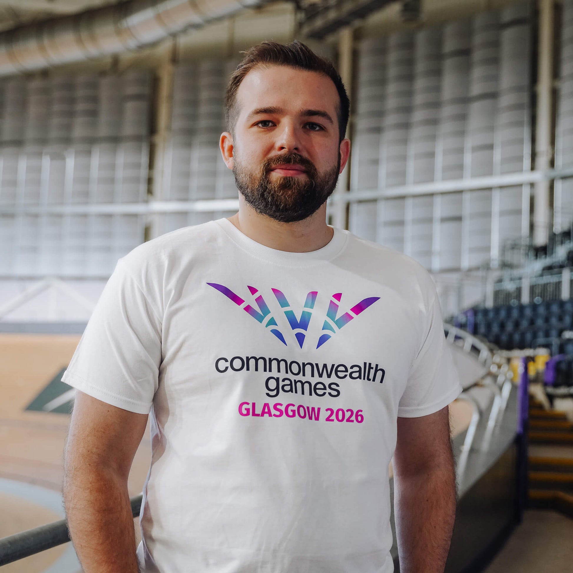 Man wearing white Glasgow 2026 logo t-shirt