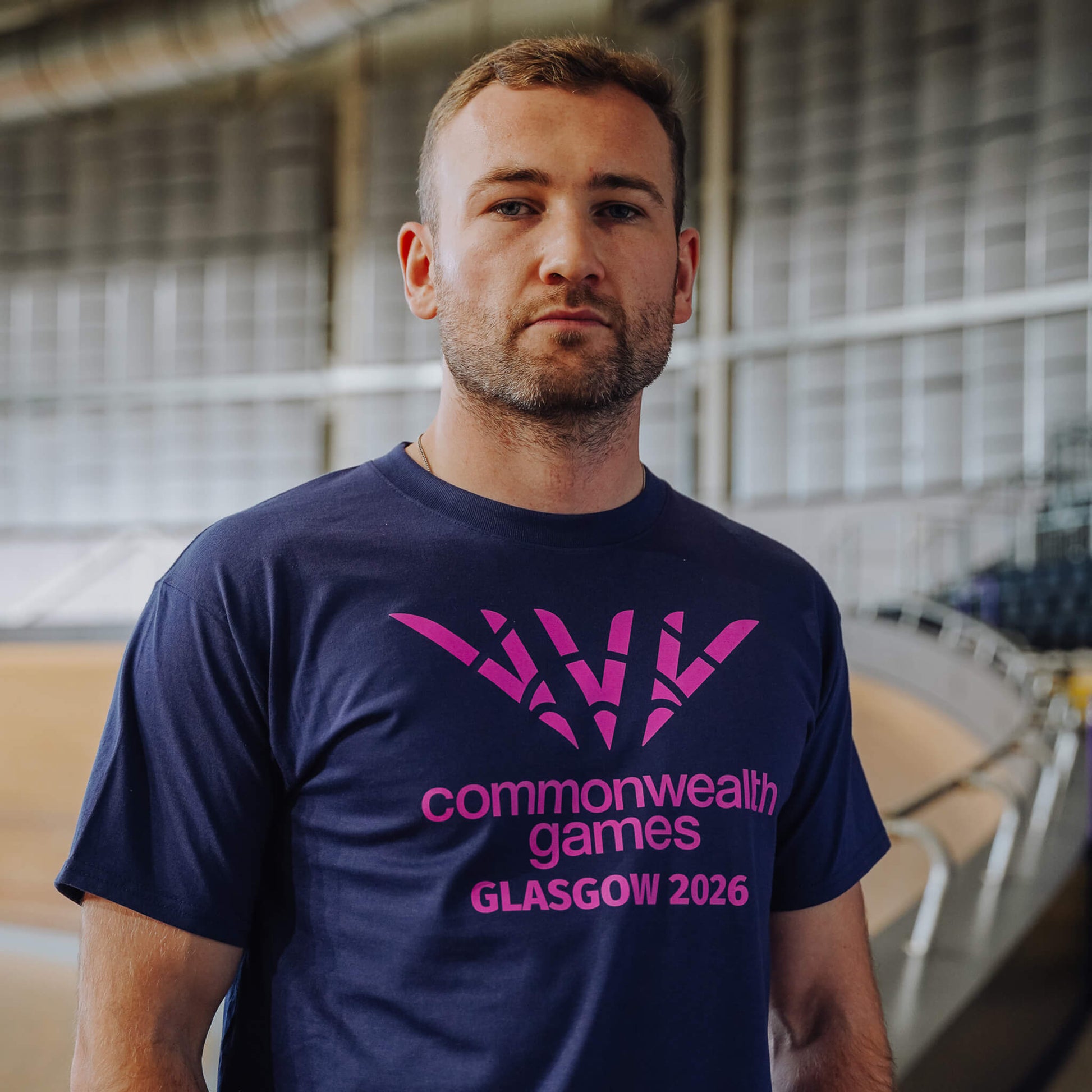 Man wearing navy single colour Glasgow 2036 logo t-shirt